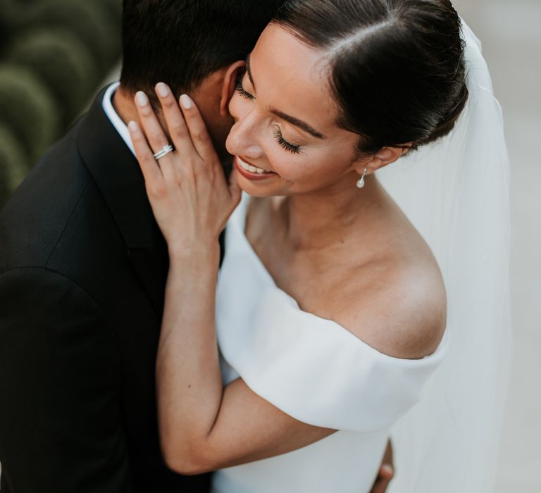 Bride holds her hands up to grooms head as they embrace on their wedding day | Hannah MacGregor Photo & Film