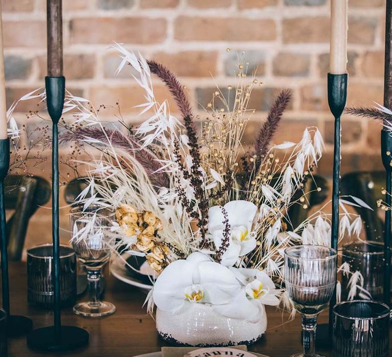 Dried grasses and white orchid wedding flower centrepiece decor 