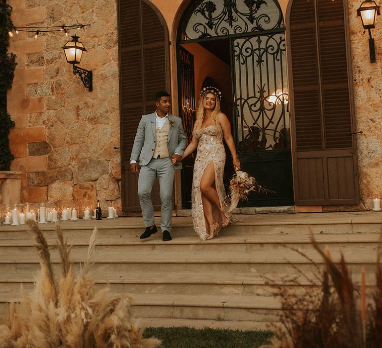 Bride & groom stand on staircase outdoors on their wedding day