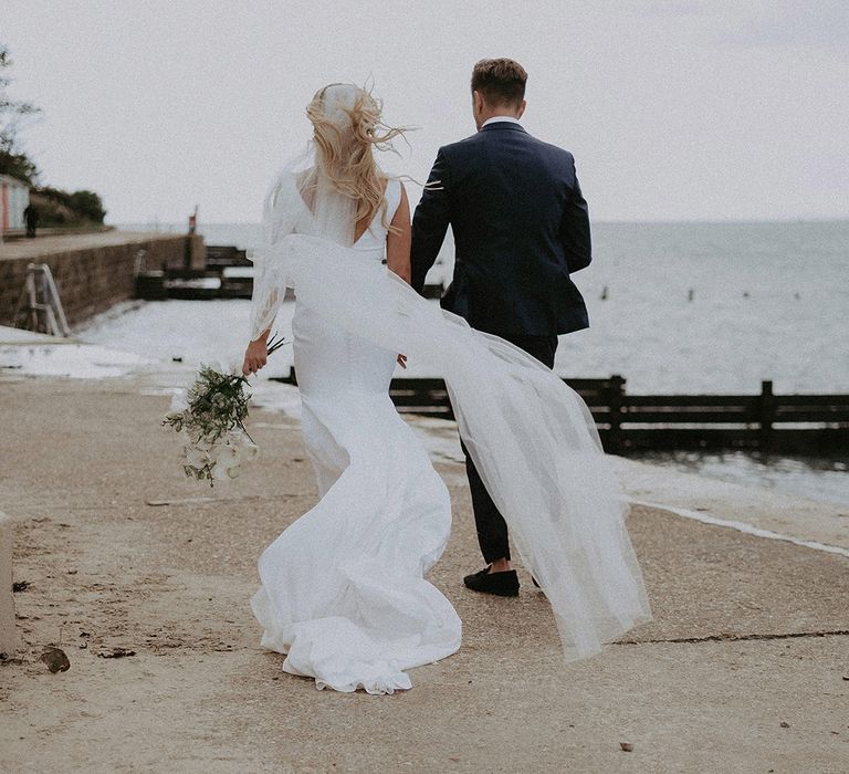 Brides veil blows in the wind at coastal wedding with Isle of Wight wedding photographer