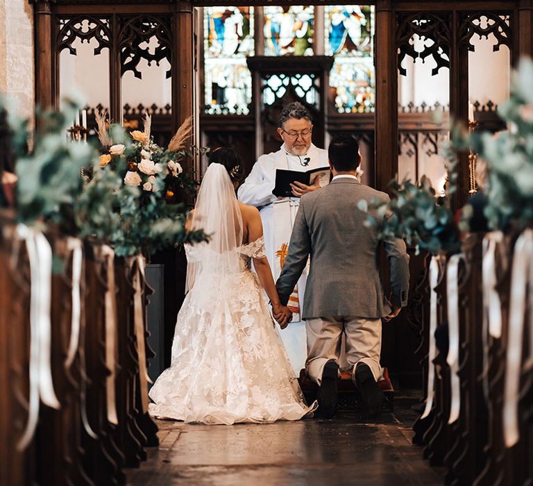 Bride and groom on their knees for church wedding ceremony 