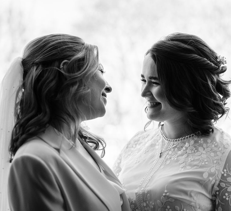 Two brides look at one another lovingly in black and white image