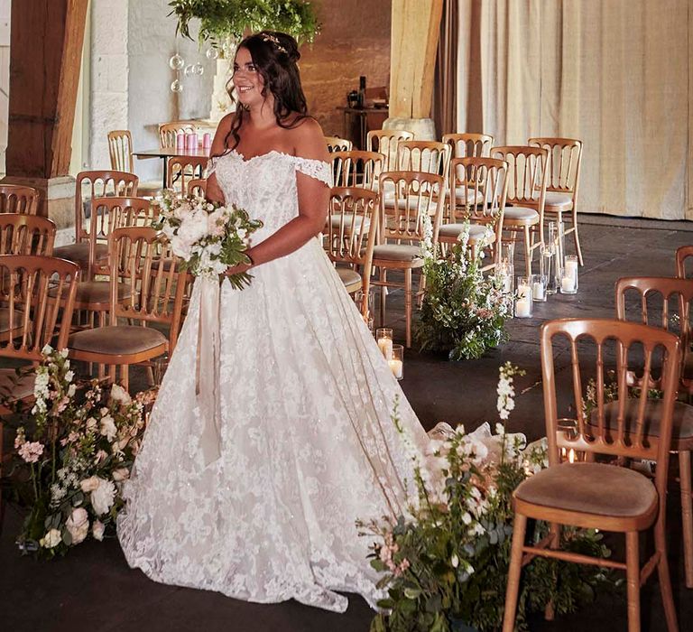 Bride in an off the shoulder lace wedding dress walking down the aisle at East Riddlesden Hall 