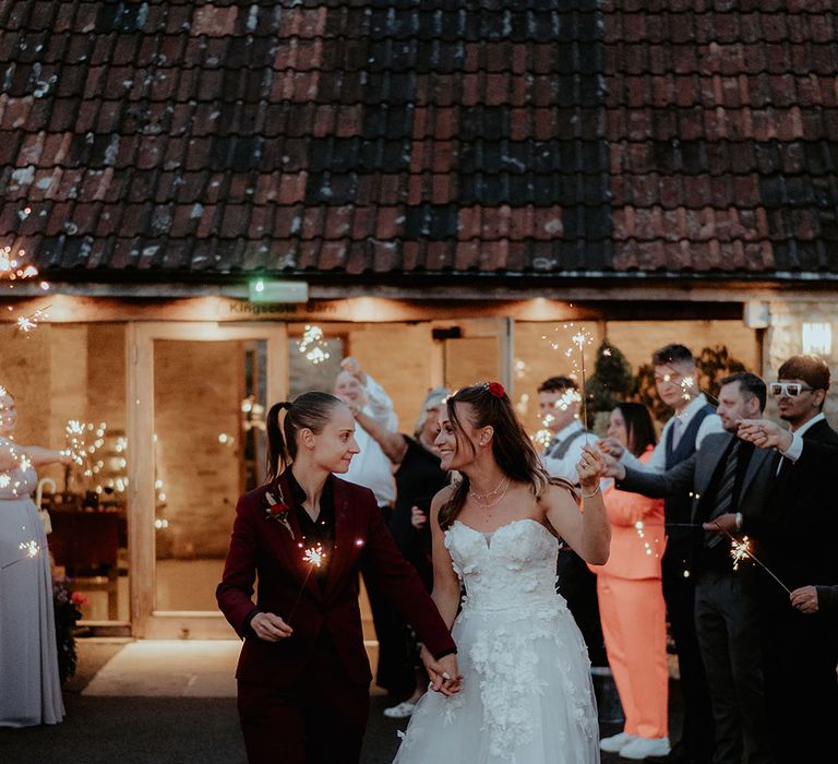 The brides have a classic sparkler send off from their rustic barn wedding 