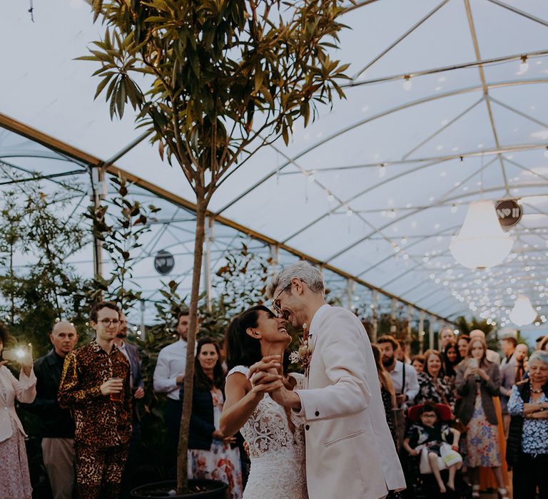 Bride and Groom share intimate dance with fairy lights in the background