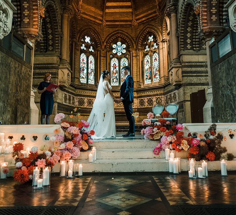 Colourful cascading florals line stairway during church wedding ceremony at St Stephen's Hampstead 