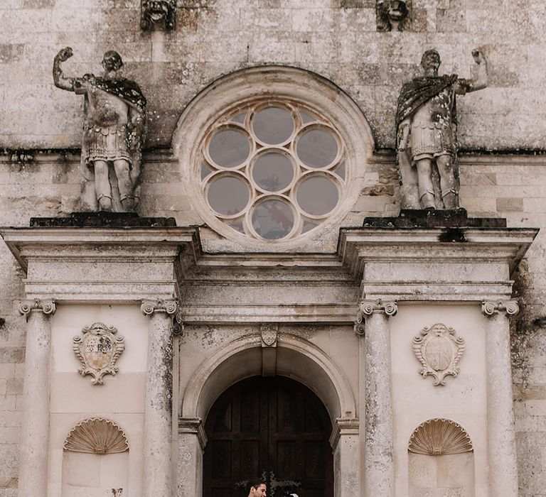 Lulworth Castle wedding venue in Dorset with the bride and groom posing for couple portraits together 