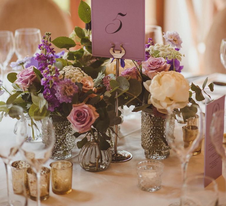 Elegant and classic wedding table name ideas with purple table number sign 