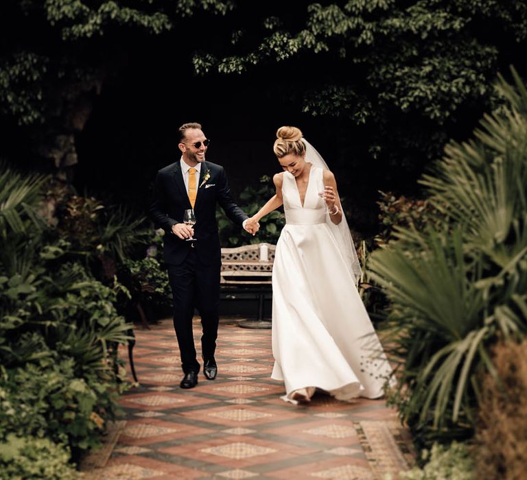 Gift list wedding at Hampton Court House in Surrey with bride in plunging Sheila Harding wedding dress with groom in navy suit 