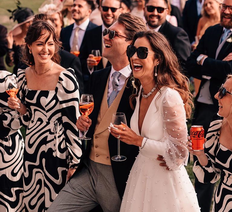 The bride and groom drink Aperol Spritz wedding cocktail hour out on the lawn of the country house wedding 