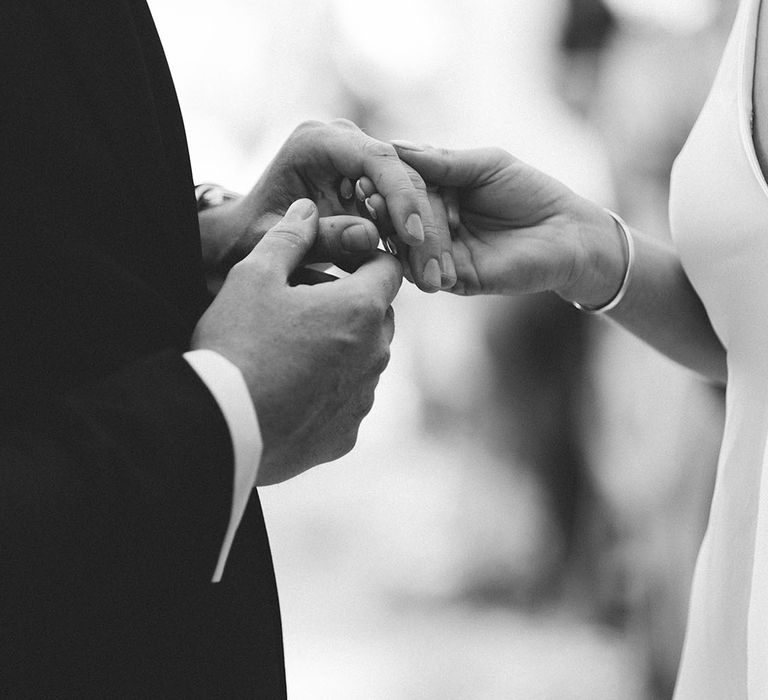 Groom puts on bride's wedding ring during the wedding ceremony 