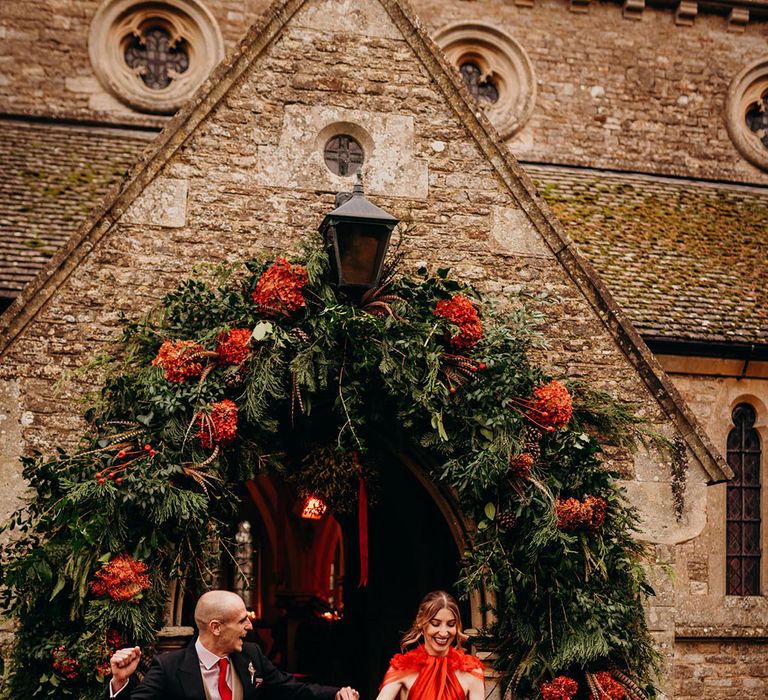 Flower arch large floral entrance decoration for winter wedding with red hydrangeas and lots of foliage 