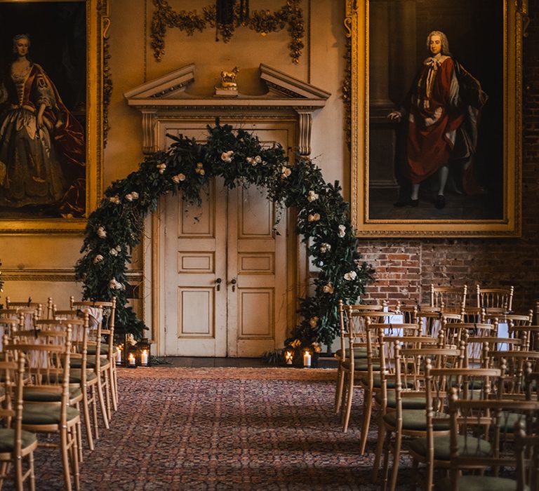 Luxe wedding ceremony room at St Giles House with white flower arch altar decoration 