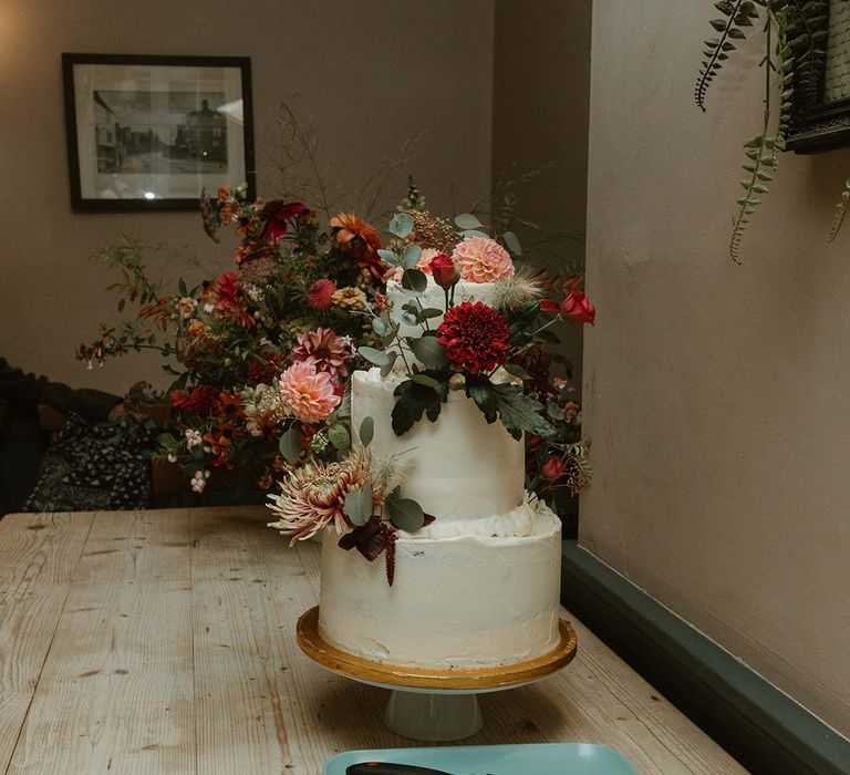 Two tier white frosted wedding cake with floral decorations 