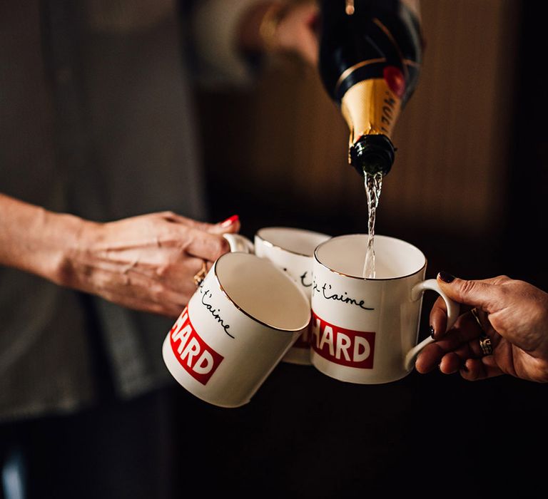 Champagne being poured into mugs 