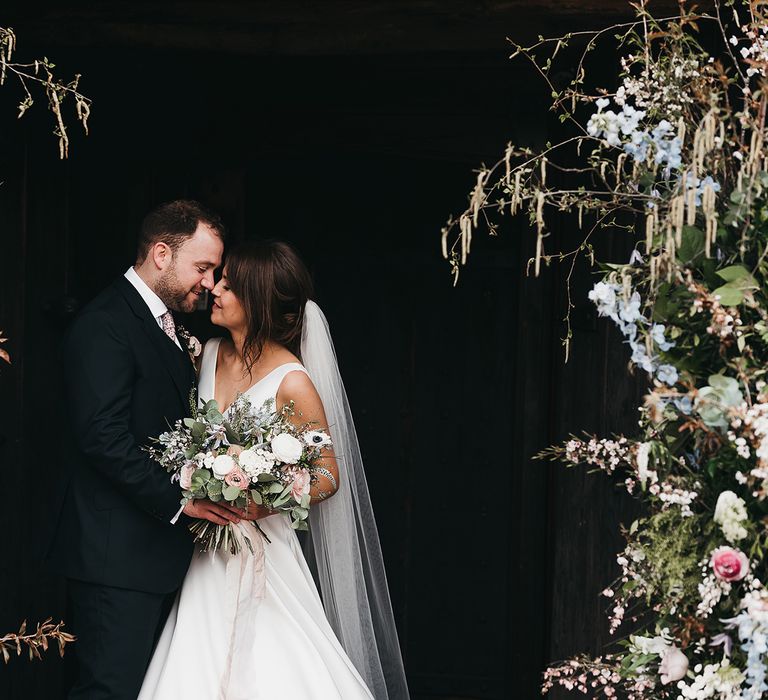 Bride and groom with wedding flowers at Brinsop Court