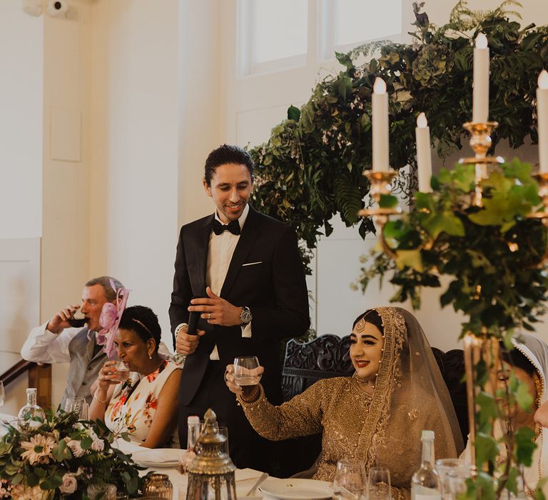 Groom speech at wedding reception filled with botanical plants and flowers 