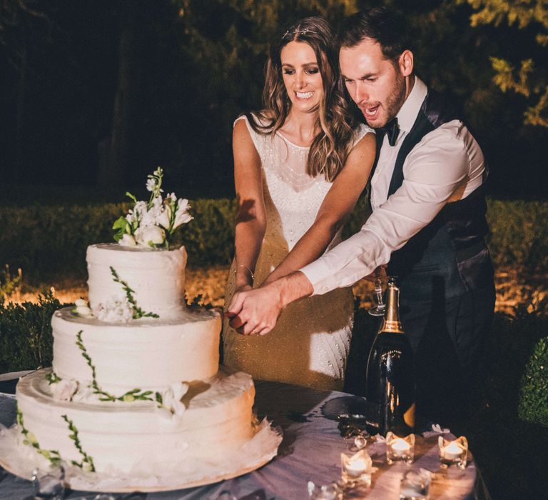 Newly-wed couple cutting cake at Italian outdoor wedding