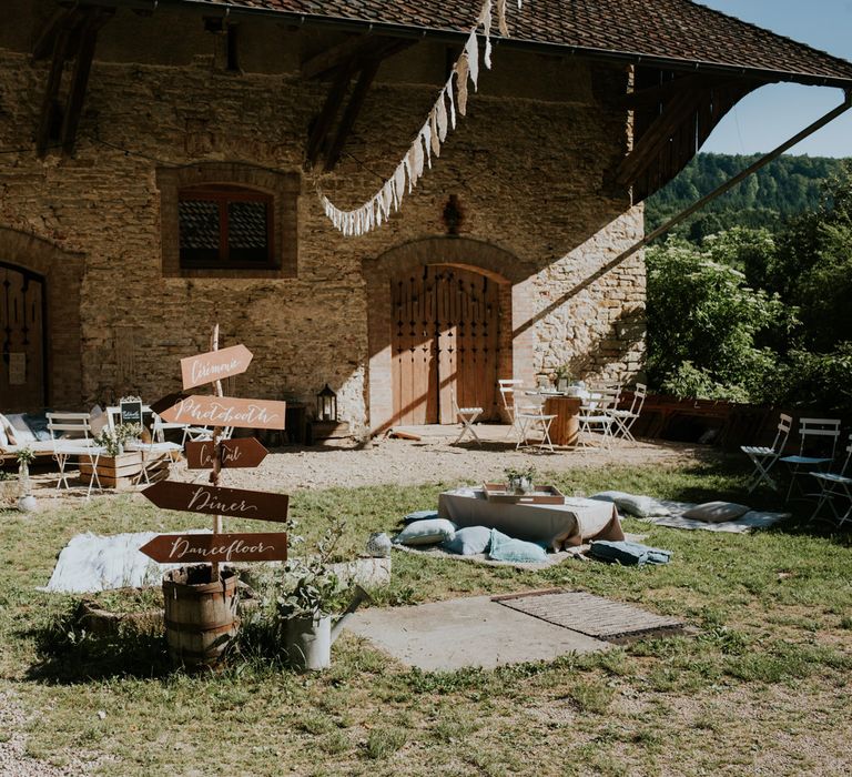 Rustic outdoor wedding with bunting and wooden signpost