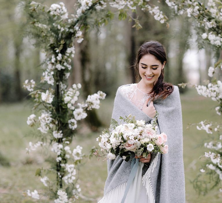 Bridal shawl and flower arch for outdoor wedding at Chateau de la Ruche