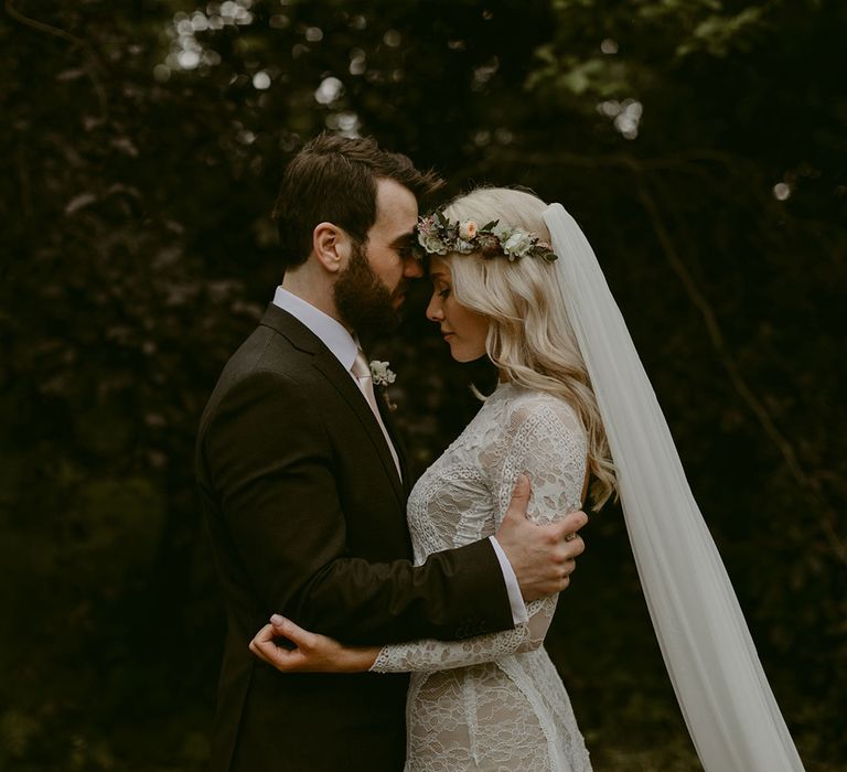 Bride in Grace Loves Lace wedding dress and single tier cathedral length veil hugs groom in black Hugo Boss suit at Drenagh Estate Wedding