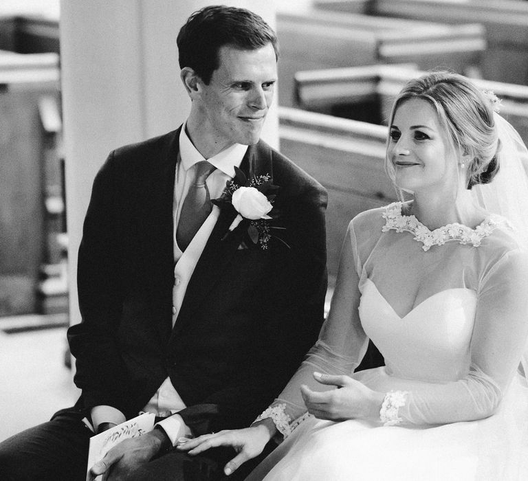 Black & white image of bride & groom sat together on wedding day