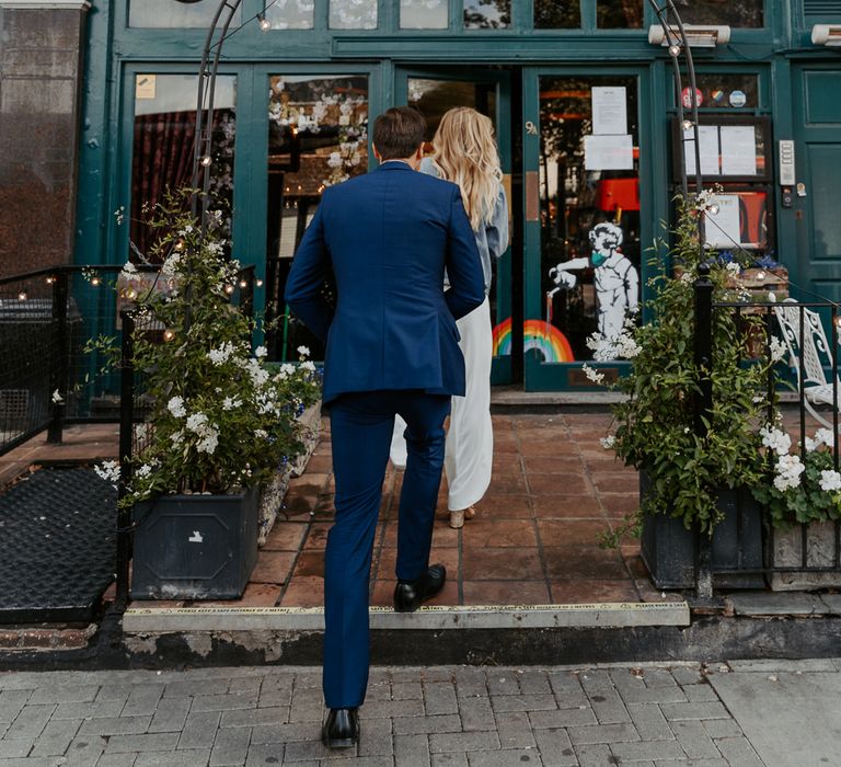 Bride & groom walk into Metro Clapham for wedding reception