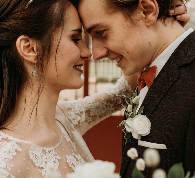 Intimate bride and groom portrait with groom wearing a delicate white flower buttonhole 