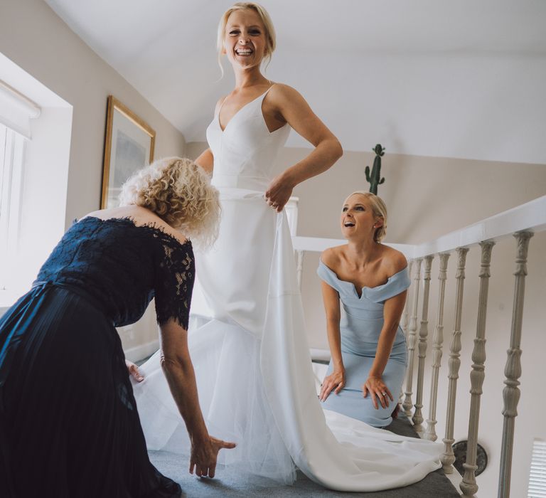 Bride has her dress adjusted on the morning of her wedding