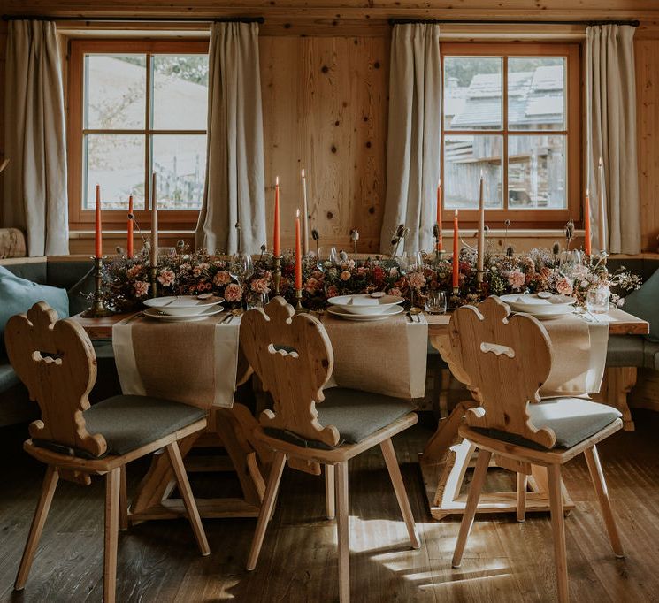 Intimate tablescape at Dolomites wedding with orange taper candles and dried flower centrepiece arrangement 