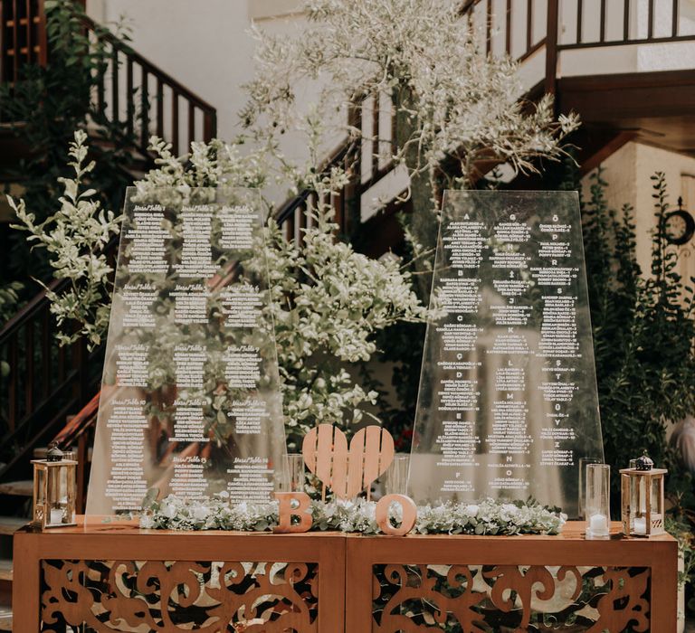 Transparent wedding seating chart with white flowers and pillar candles for Turkish Wedding