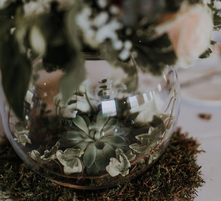 Wedding centrepiece with upturned bowl and succulents inside.