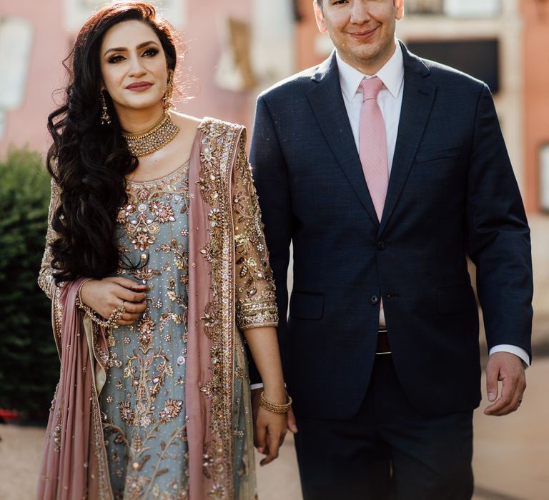 Bride & groom walk together as they hold hands