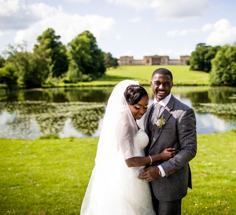 Bride & groom stand with one another outdoors on their wedding day