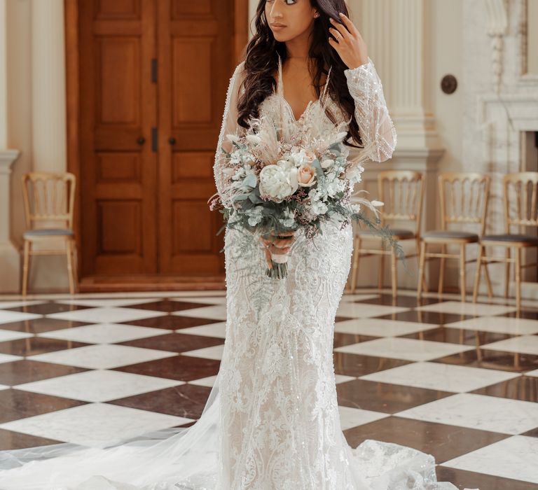 Bride stands within room with black & white chequered flooring on her wedding day