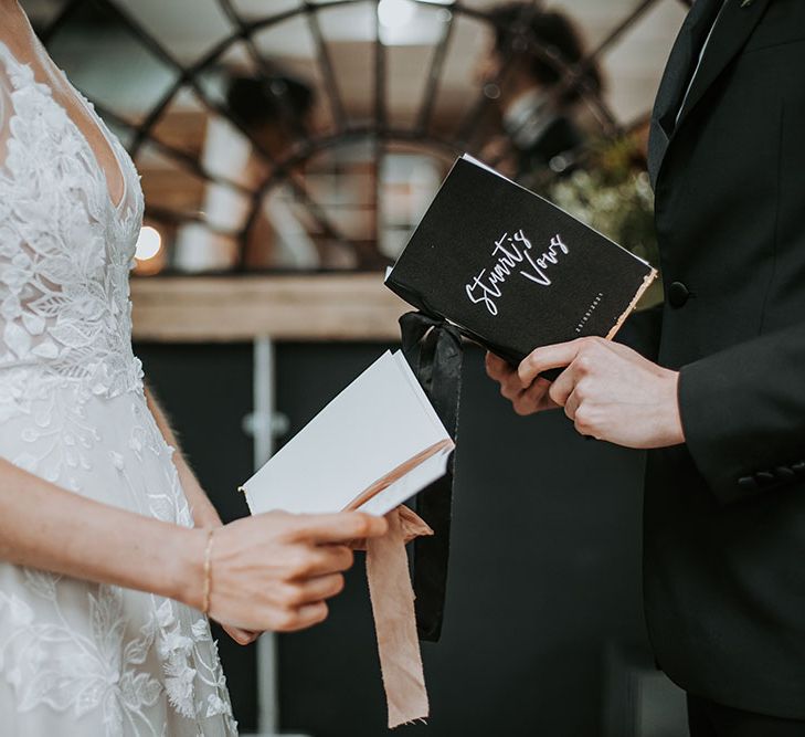 Personalised vow books with ribbon decor at rustic wedding 