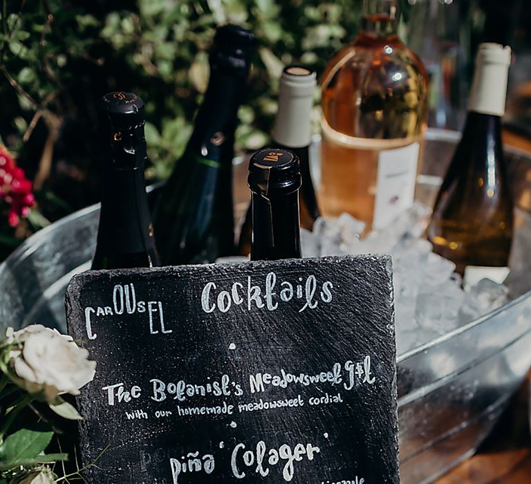 Wedding cocktail menu written on a slab of black slate with white ink 