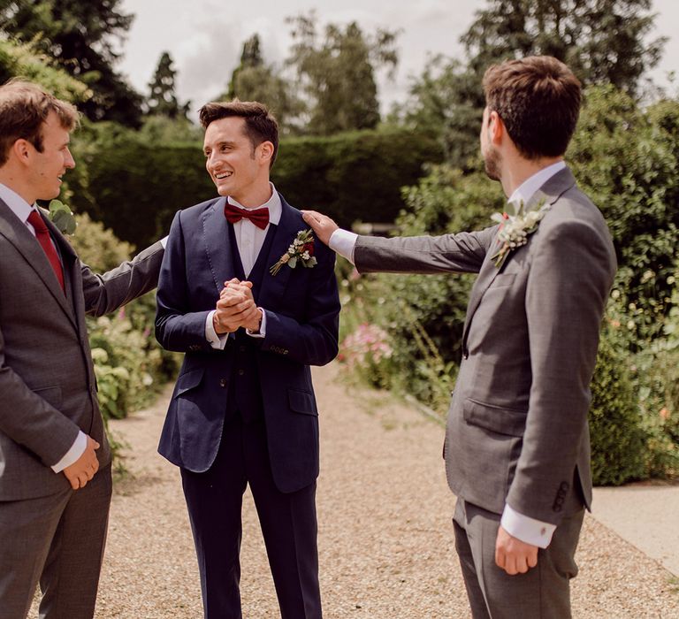 Groom stands with his groomsmen on his wedding day outdoors | Joshua Gooding Photography