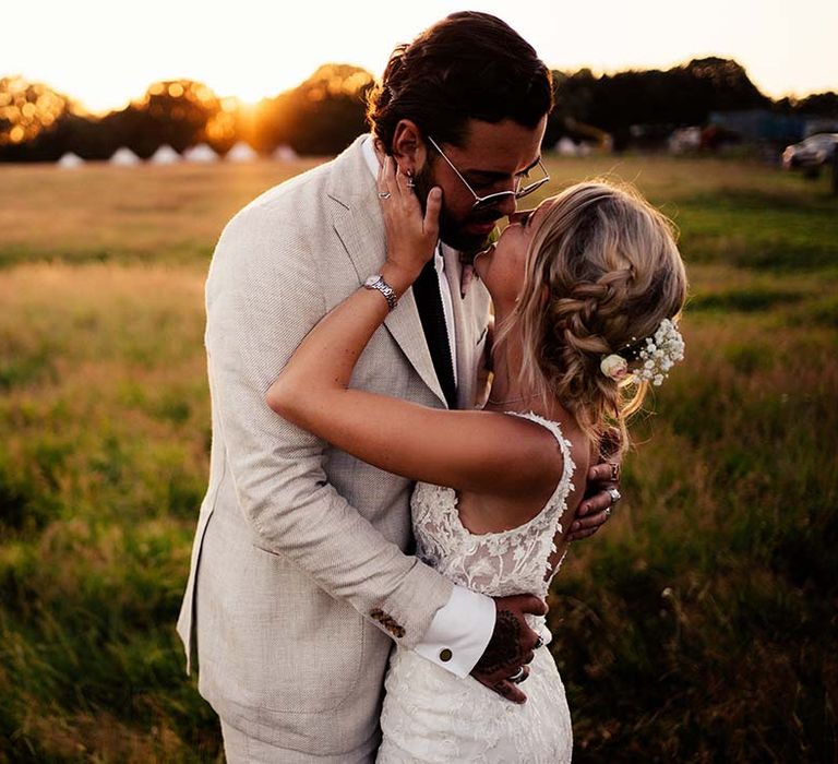 Bride and groom share a kiss at sunset