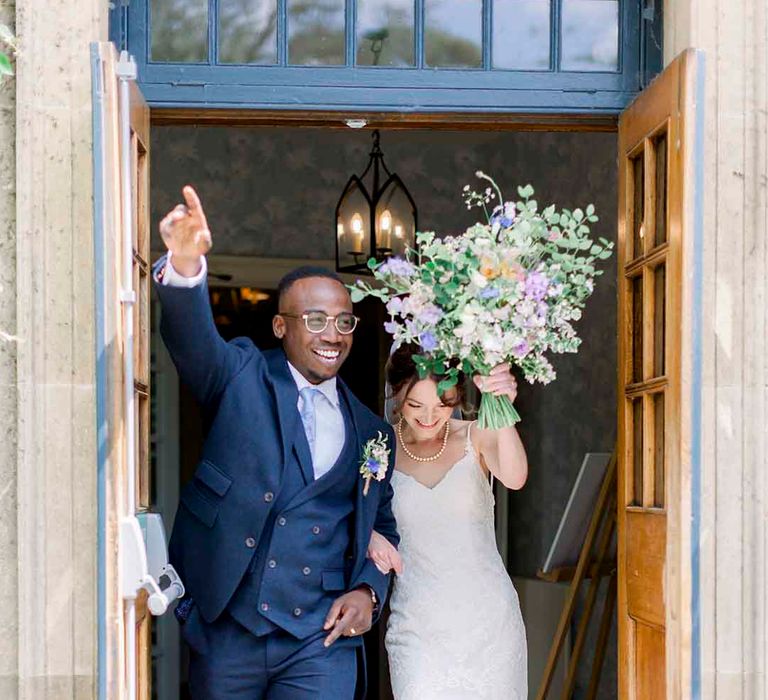 Bride & groom wave and smile after ceremony