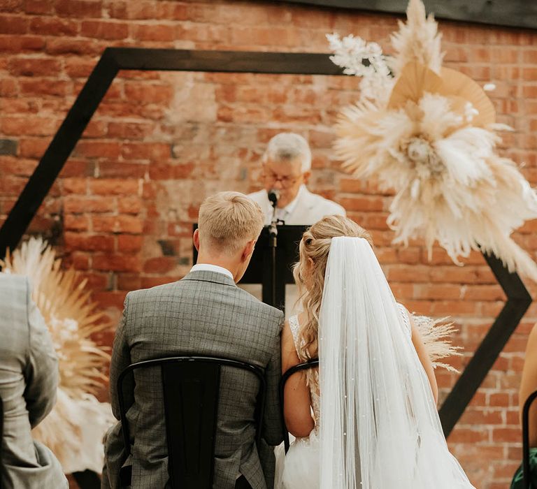 Bride wears long veil in half up half down hairstyle during civil ceremony