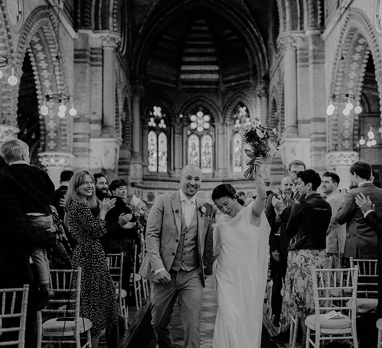 Bride & groom celebrate as they walk down the aisle | Irene Yap Photography