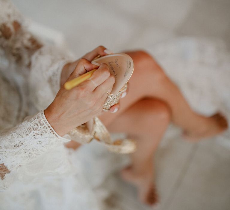 Bride writes on the bottom of her wedding shoes