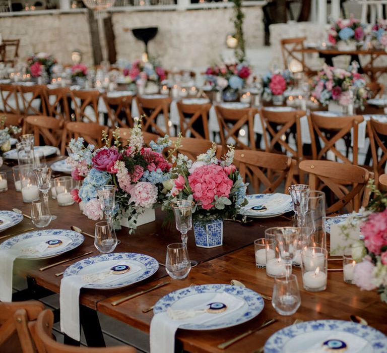 Bright florals line banquet wooden tables complete with white and blue china plates 