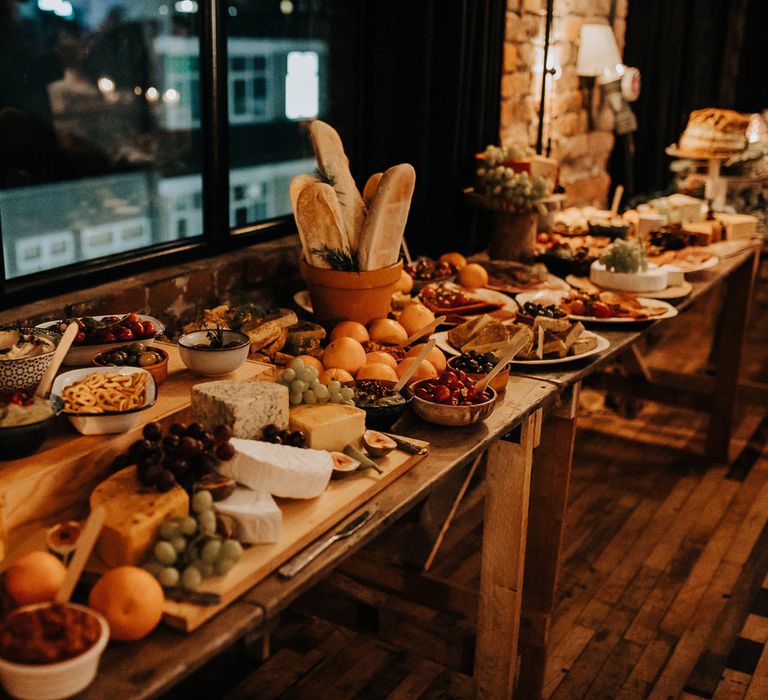 Large wedding grazing table with bread, olives and fruits for industrial rustic style wedding in Liverpool