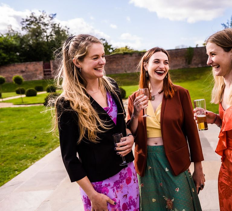 Wedding guests socialise together outside ceremony room 