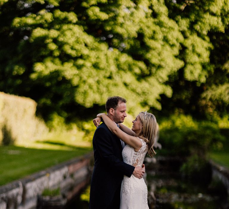 Cute couple portrait of bride and groom on their wedding day at Goldney Hall with bride in lace wedding dress and groom wearing traditional morning suit 