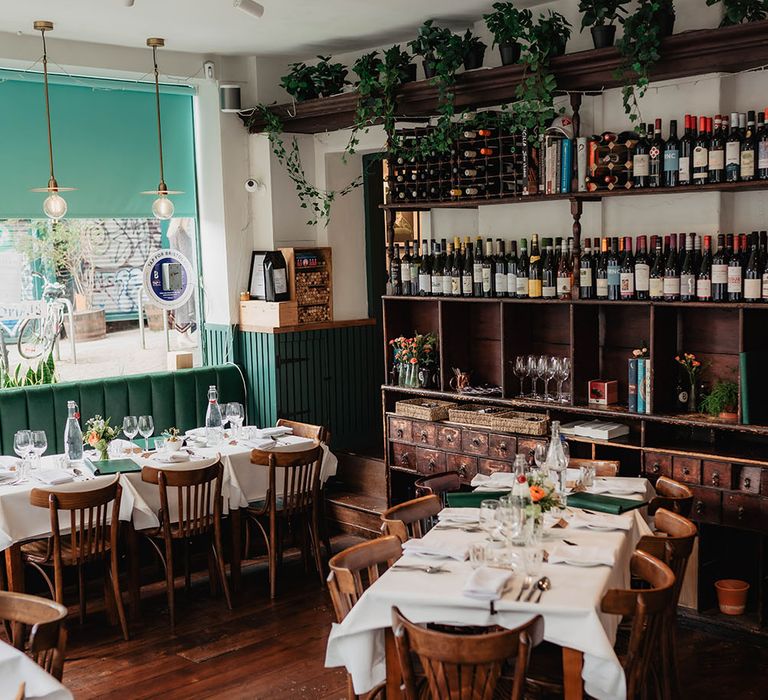 Restaurant reception dinner complete with green napkins and homegrown floral decor in rustic setting 