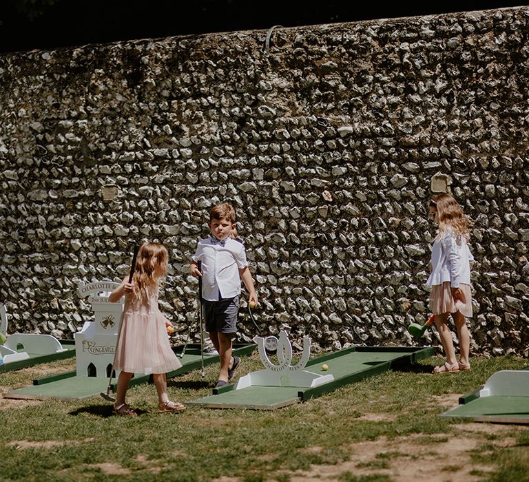 Kids attending the wedding play with the mini golf set 