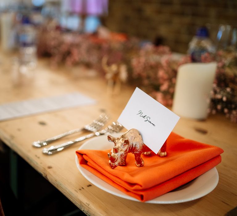 Orange fabric napkin with spray painted gold toy animal for DIY place settings 